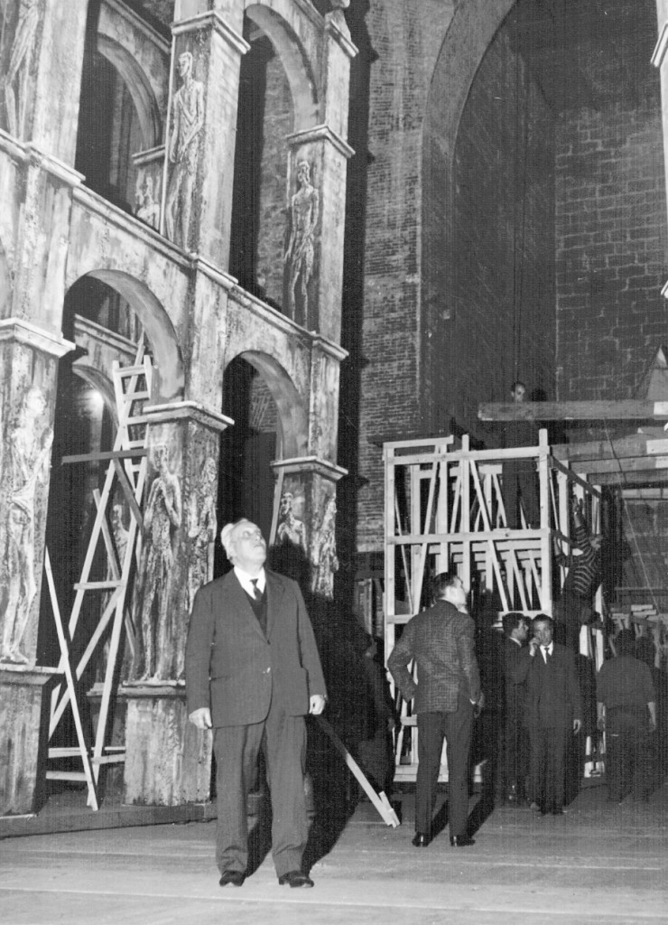 Fotografia d'epoca di Giuseppe Pipi in teatro, fra scenografie e strutture di legno