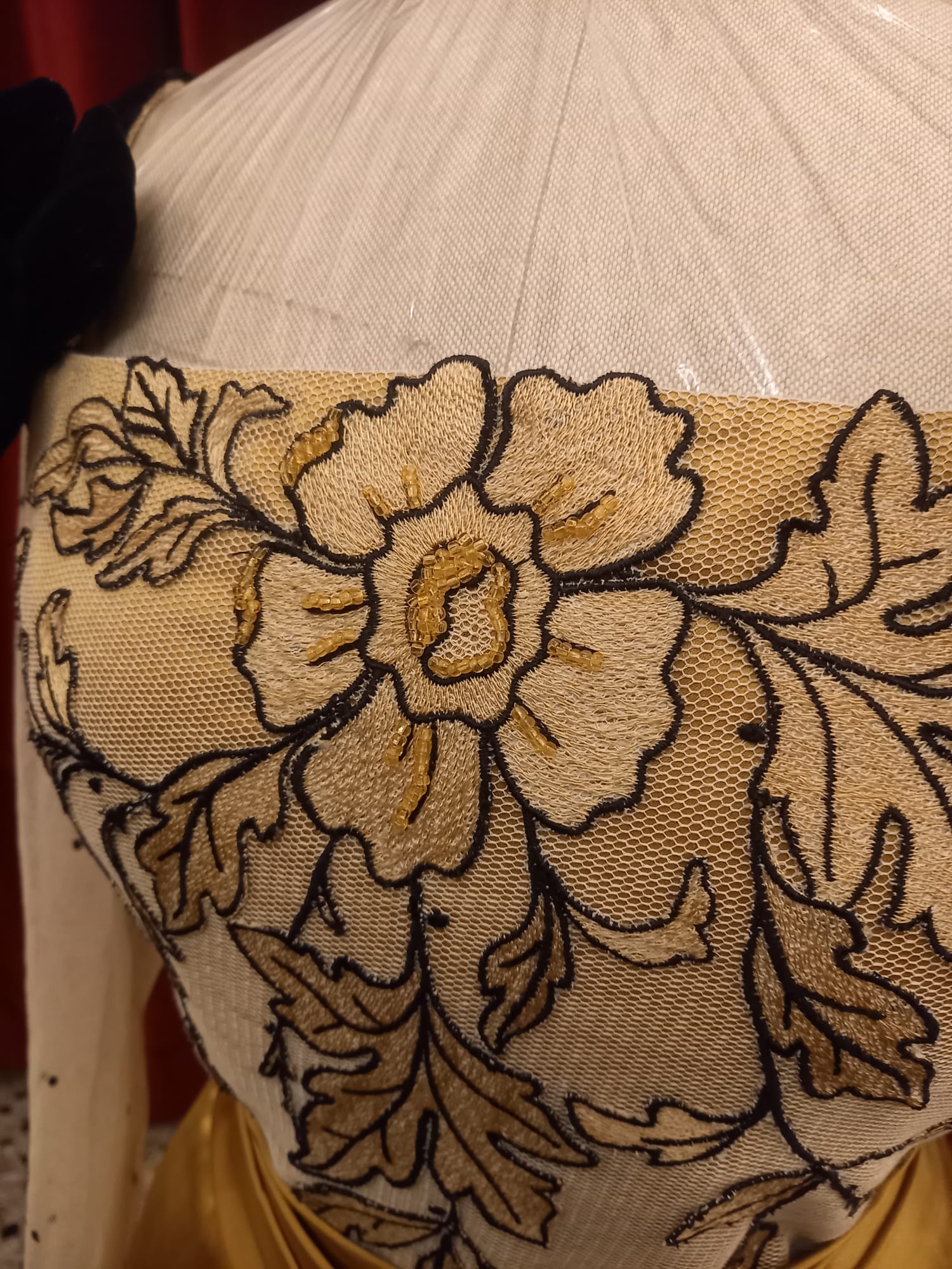 Ricamo a mano in filo d'oro su velluto rosso nell'atelier della Sartoria Pipi